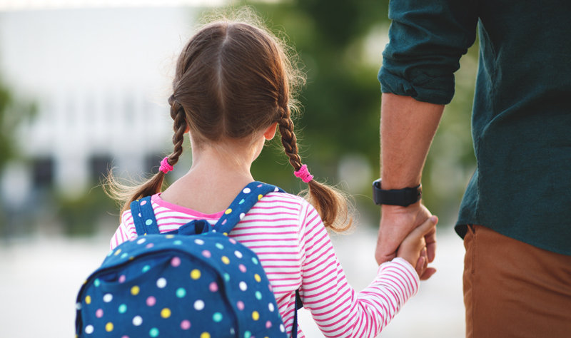 young girl and dad walking to school