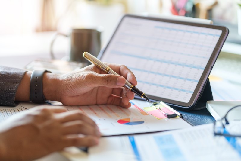 A businessman looking at a tablet and finances by Century Support Services