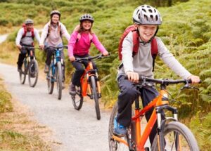 Group of cyclists riding along a nature trail surrounded by greenery