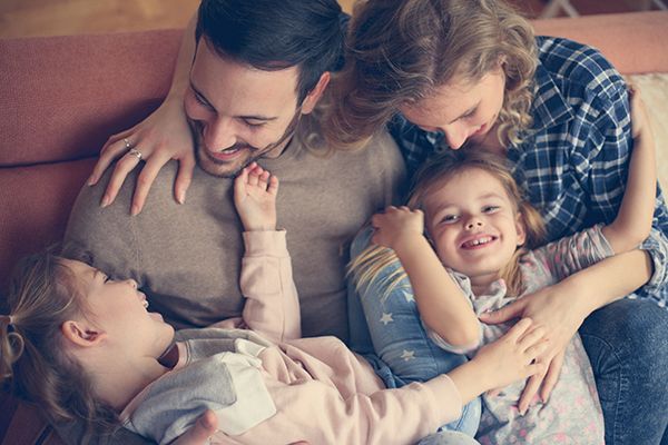 Family sitting together on a couch, sharing a warm and affectionate group hug