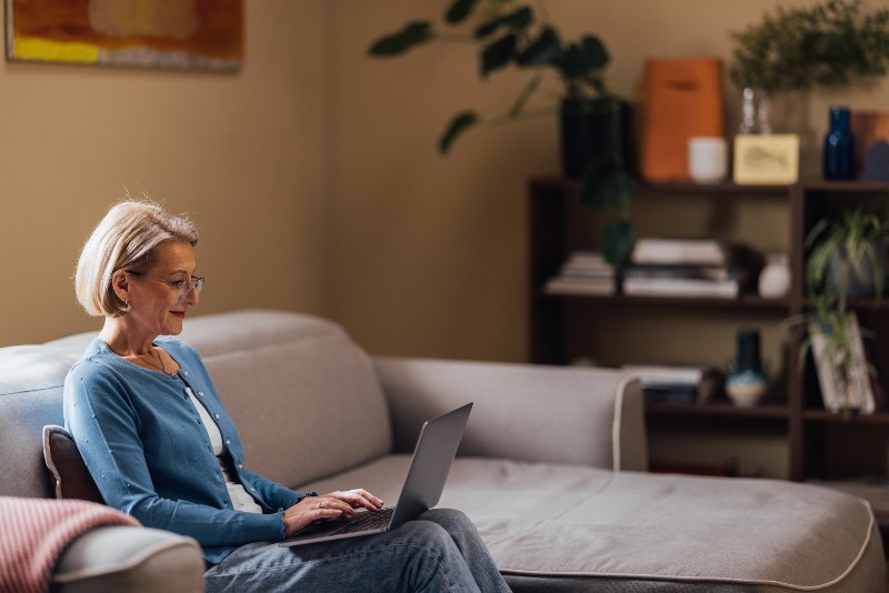 An elder woman on her laptop learning financial literacy by Century Support Services